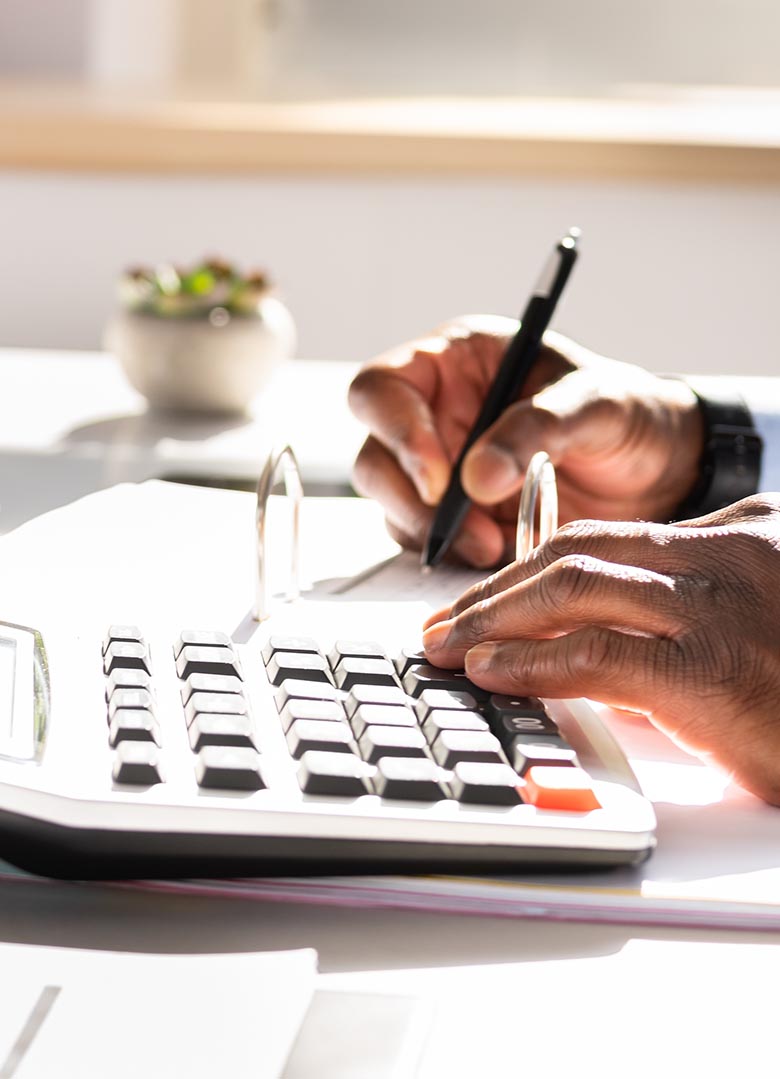Ein Mann am Taschenrechner mit Stift in der Hand